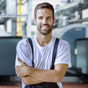 Ein Anlagenmechaniker der seine Arme verschränkt